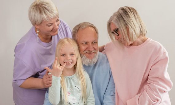 A joyful multigenerational family poses and smiles together indoors, showcasing love and togetherness.